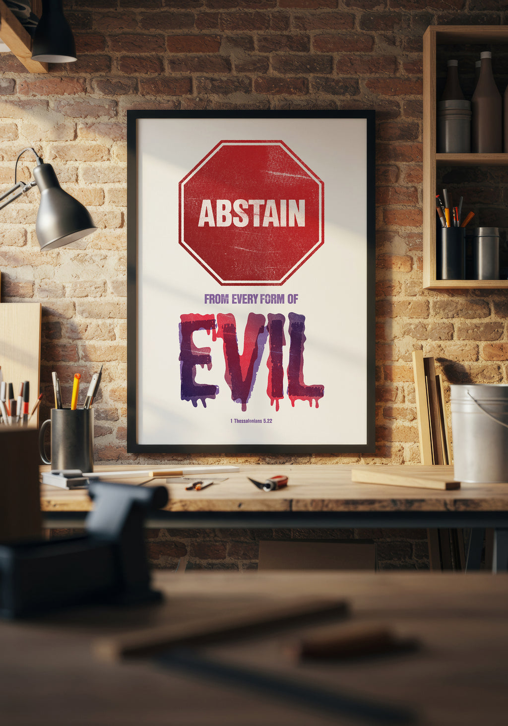 1 Thessalonians 5:22 print in a black frame, styled above a workbench in a home workshop.