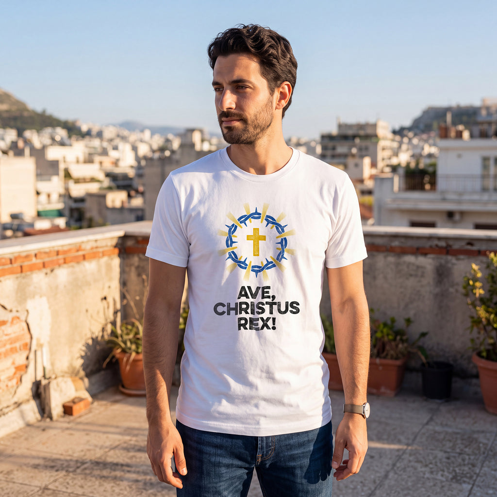 Man on rooftop terrace with cityscape, wearing white t-shirt with Ave Christus Rex graphic print.