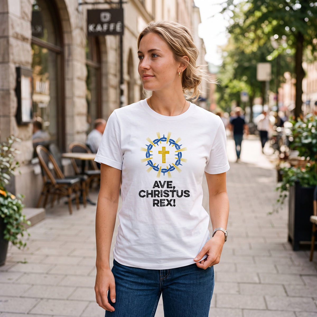 Woman on city sidewalk wearing white
t-shirt with Ave Christus Rex graphic print.