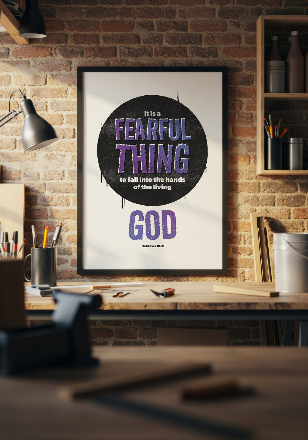Hebrews 10:31 art print in a black frame, hung above a home workbench in a beam of natural sunlight. 