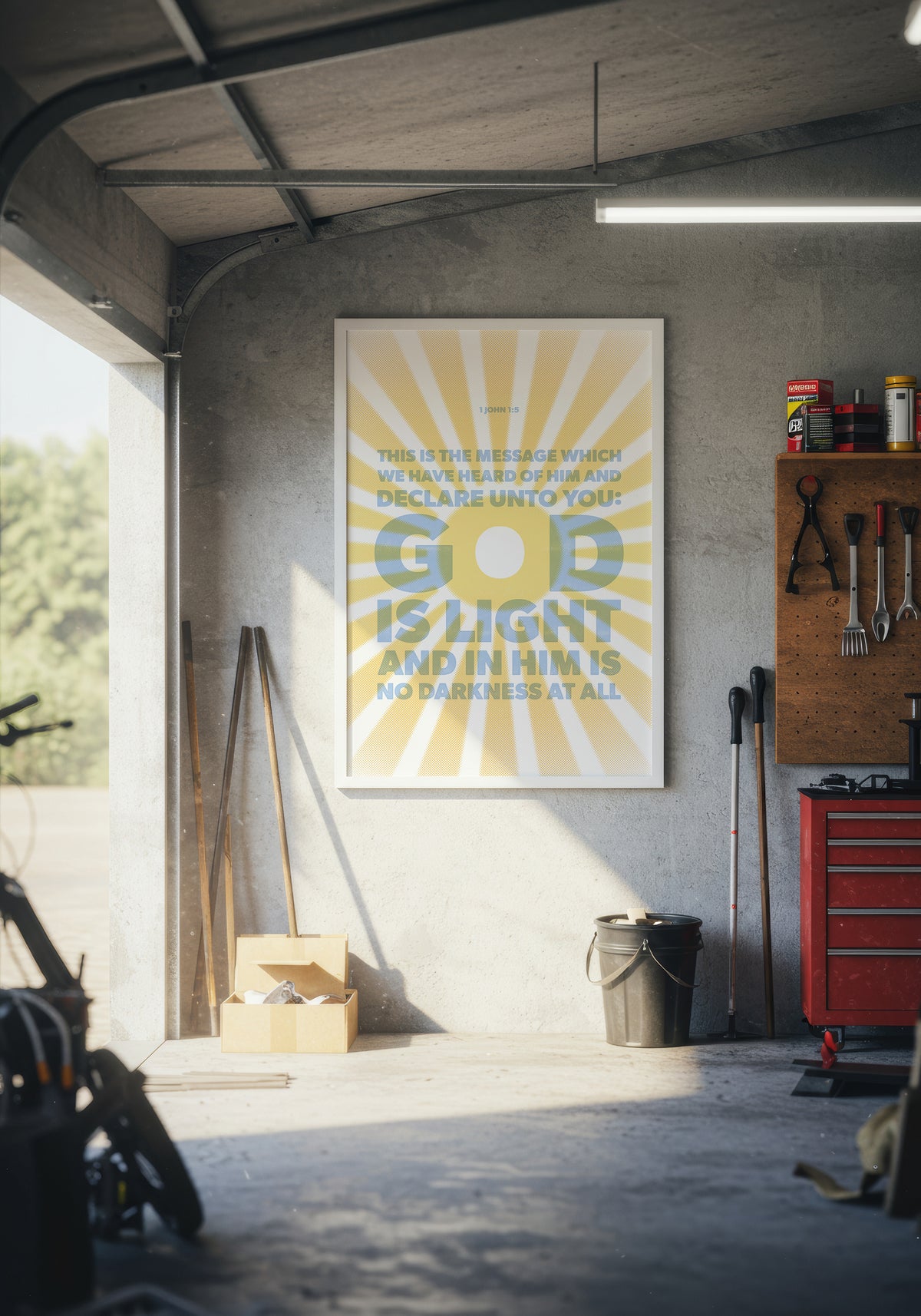 1 John 1:5 art print in a white frame, displayed on a wall in a warmly lit garage.