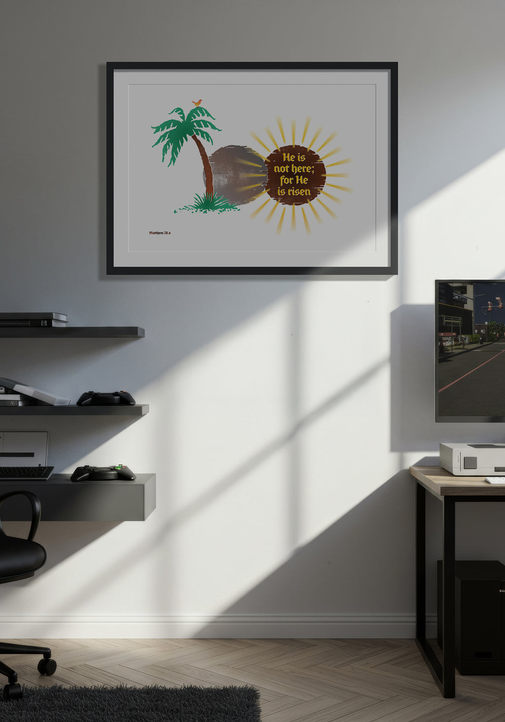 Matthew 28:6 art print in a black frame, displayed on a wall in a minimalist, warmly lit computer games room.