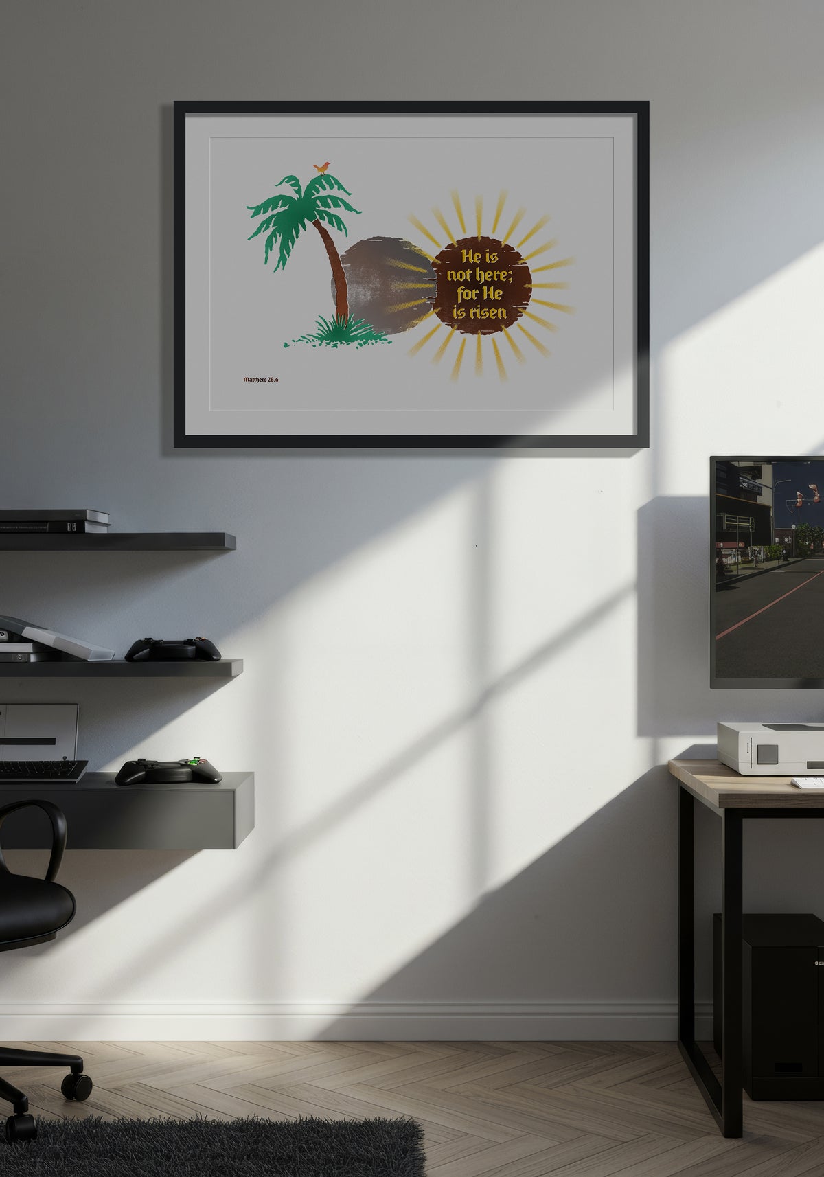 Matthew 28:6 art print in a black frame, displayed on a wall in a minimalist, warmly lit computer games room.