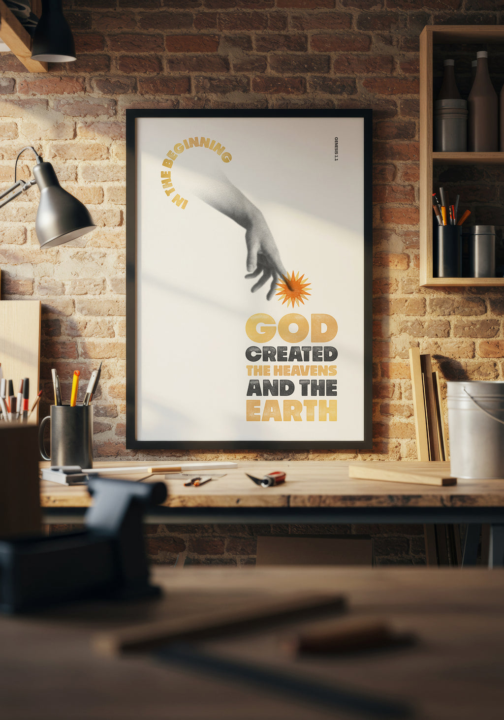 Genesis 1:1 art print in a black frame, displayed above a workbench in a warmly lit home workshop.