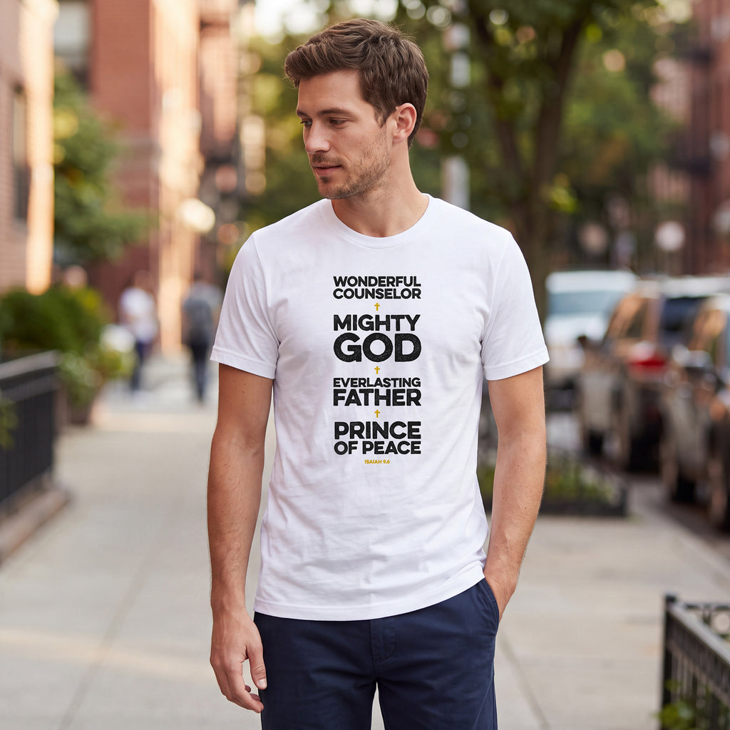 Man standing on an urban street wearing a white t-shirt with Isaiah 9.6 graphic printed on the front.